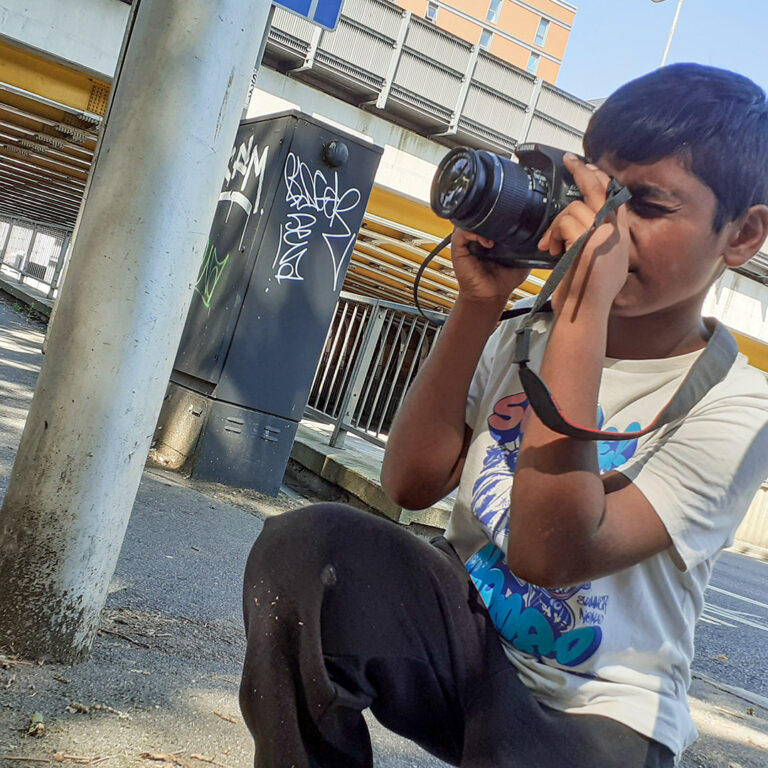 Young lad taking photo outside